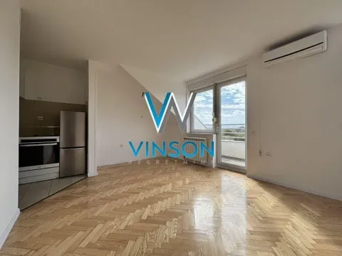 Prazna dnevna soba sa parketom i kuhinjom u uglu. - image 4