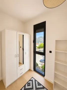 Manja spavaća soba sa bijelim garderoberom, policom i velikim prozorom. - image 10