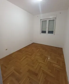 Prazna soba sa bijelim zidovima i drvenim parketom. - image 7