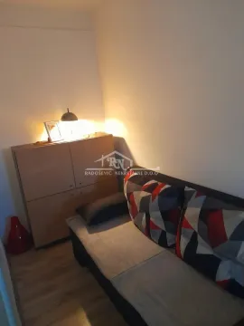 Small living room with a sofa and a cabinet with a lamp. - image 7