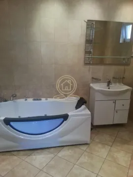 Kupatilo opremljeno hidromasažnom kadom i umivaonikom sa ormarićem. - image 2