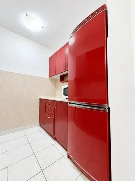 Kitchen with red cabinets and white floor tiles. - image 6