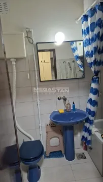 Manje kupatilo sa plavim umivaonikom, WC šoljom i kadom sa zavesom. - image 7