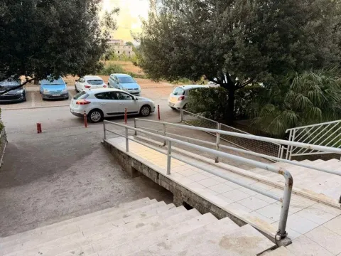 Building entrance with stairs and a wheelchair ramp. - image 13