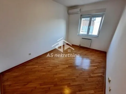 Prazna soba sa drvenim parketom, prozorom i klima uređajem. - image 14