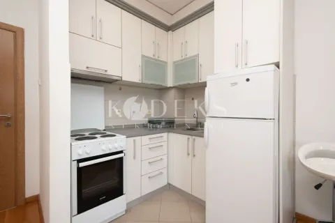 Manja kuhinja sa bijelim elementima, šporetom i frižiderom. - image 3