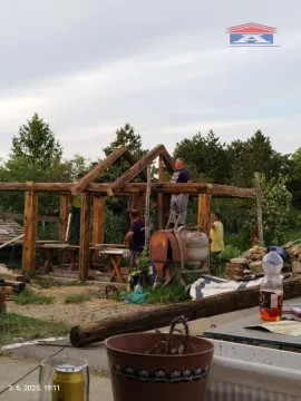 Workers are carrying out construction work on a wooden structure of a building in the yard. - image 17