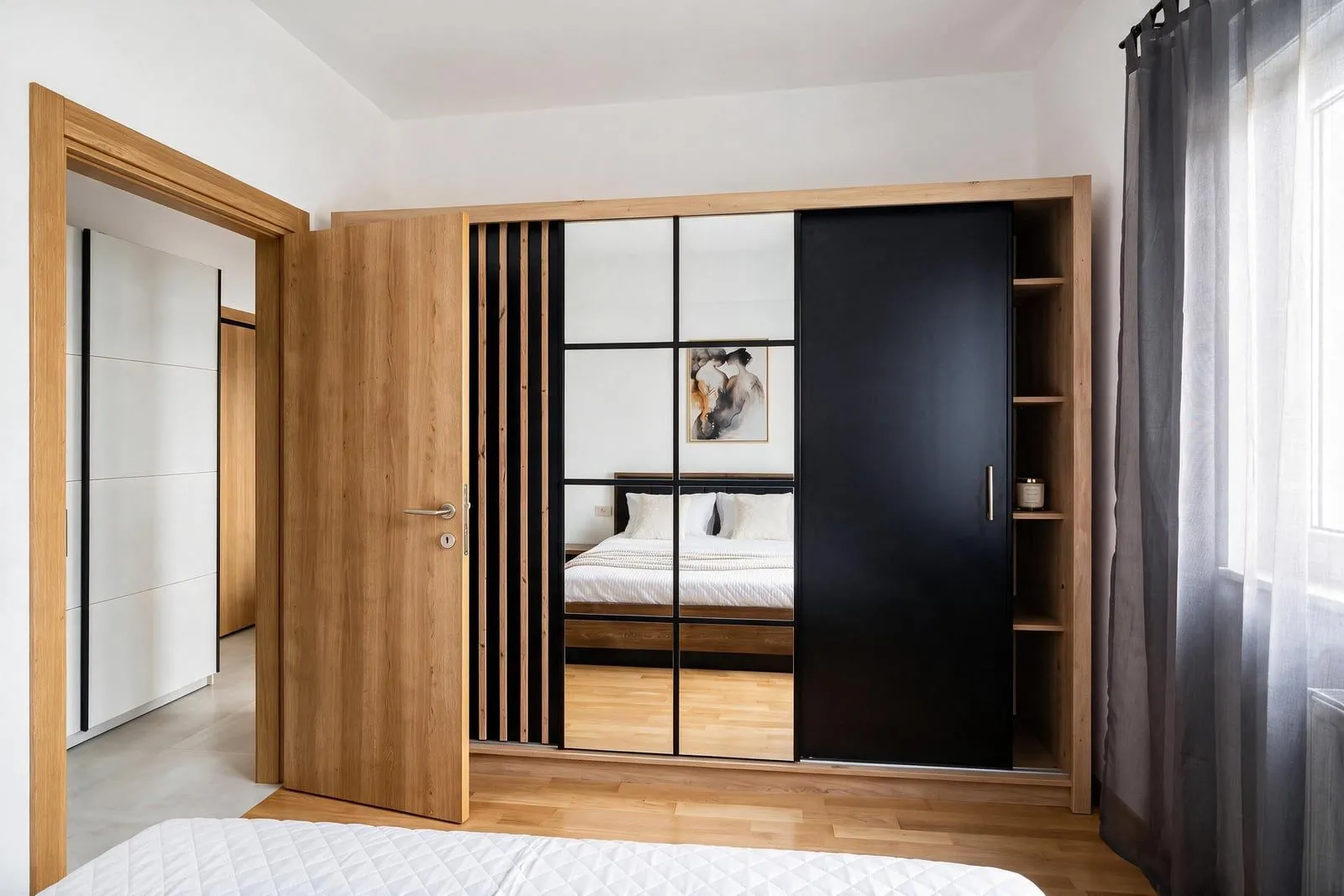 Modern bedroom with a large wooden wardrobe and a double bed.