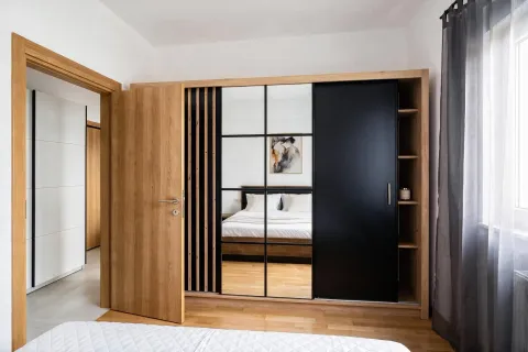 Modern bedroom with a large wooden wardrobe and a double bed. - image 7