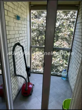 Manji zatvoreni balkonski prostor sa keramičkim pločicama i pogledom na zelenilo. - image 7