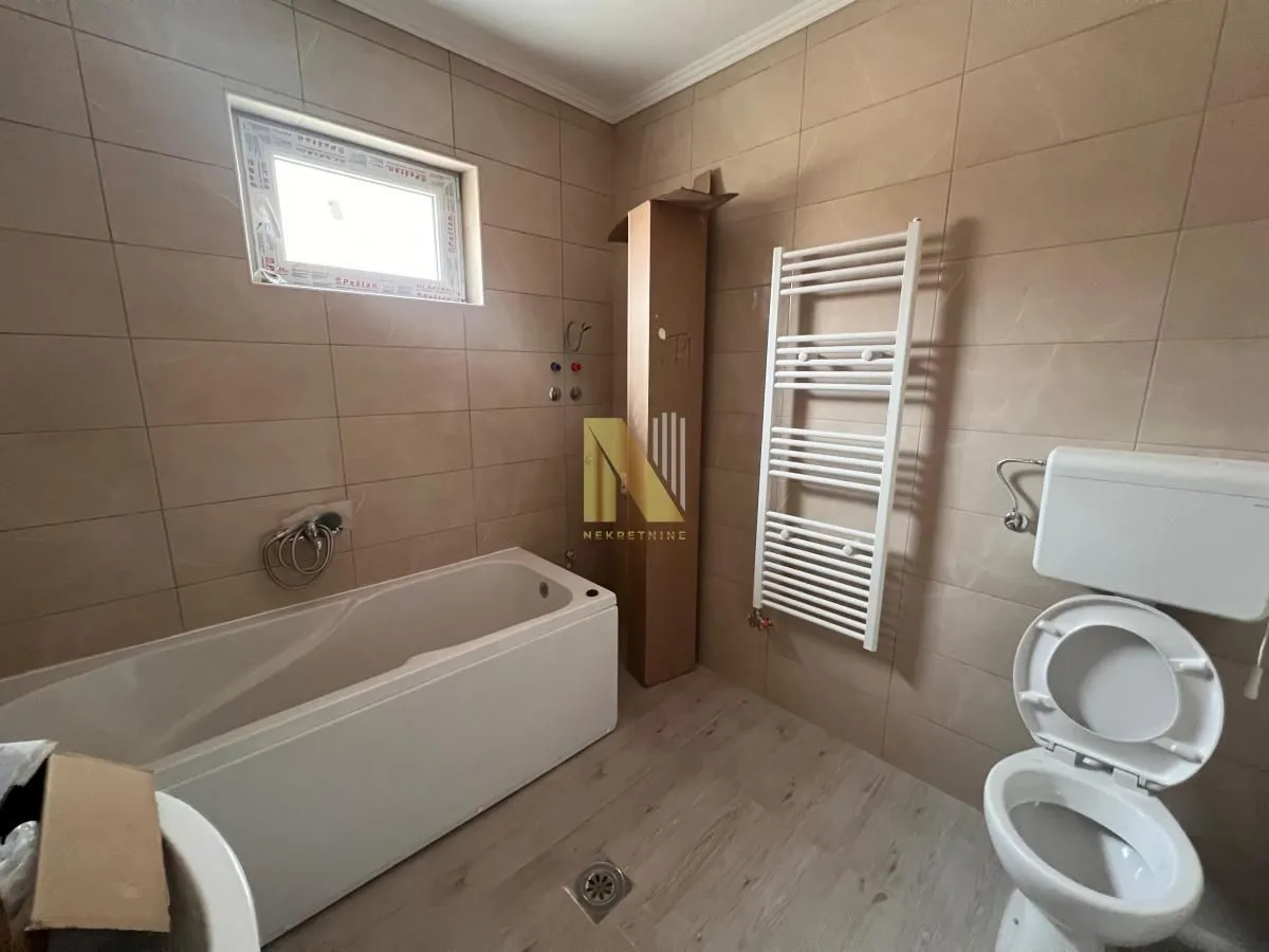 Kupatilo opremljeno kadom, wc šoljom i radijatorom sušačem.