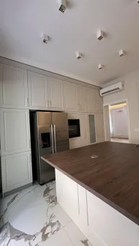 Modern kitchen with a wooden island, built-in appliances, and a large refrigerator. - image 3