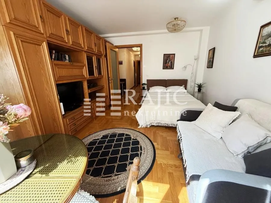 Living room with a sofa set, wooden furniture, and a dining table.