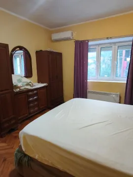 Furnished bedroom with a double bed, wooden wardrobes, and a mirror. - image 8