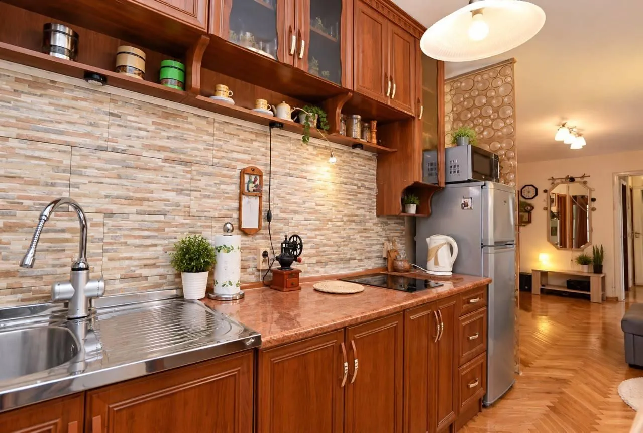 Wooden kitchen with a sink, countertop, and wall cabinets.