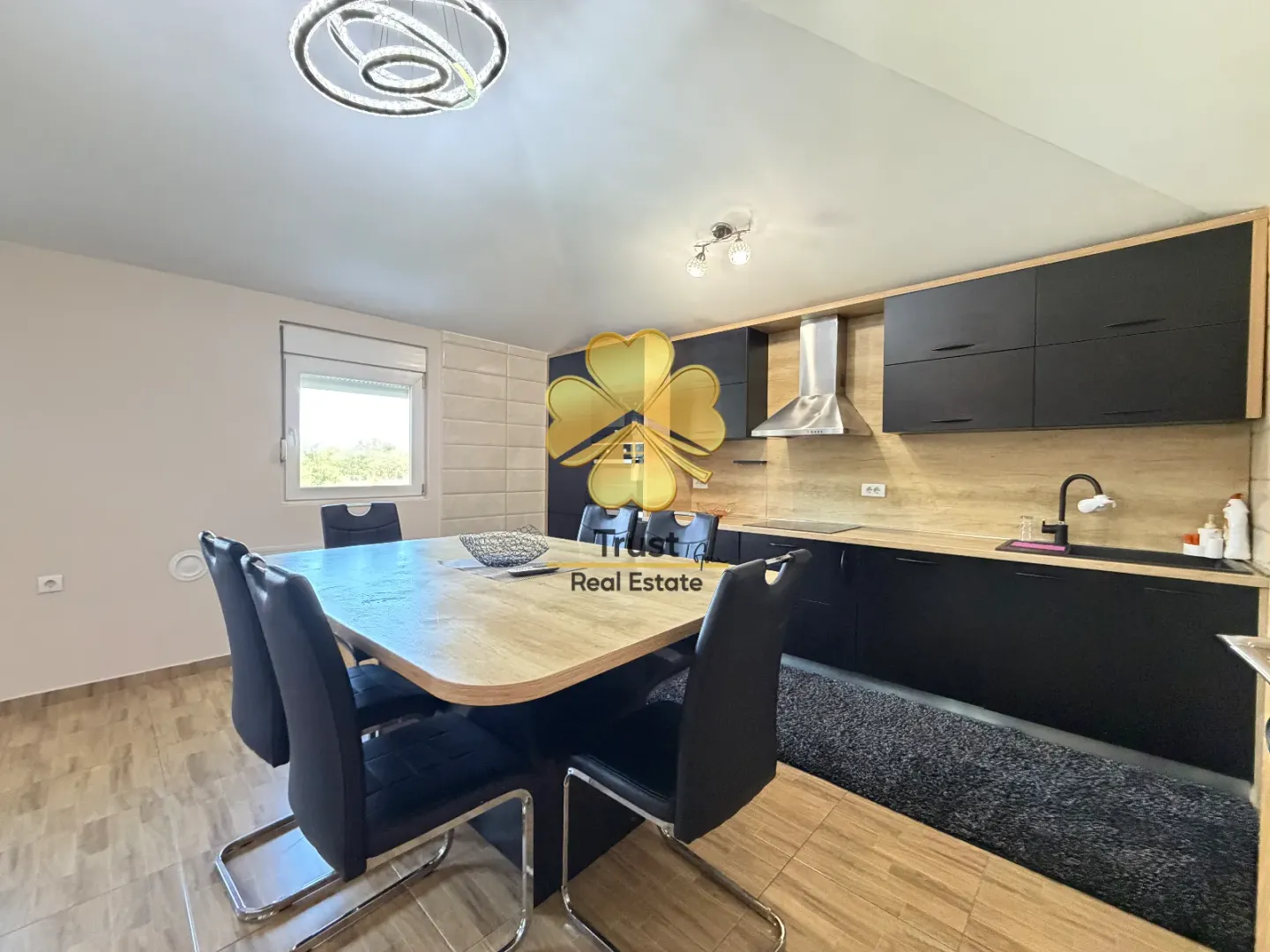 Modern kitchen with a dining table and black elements.