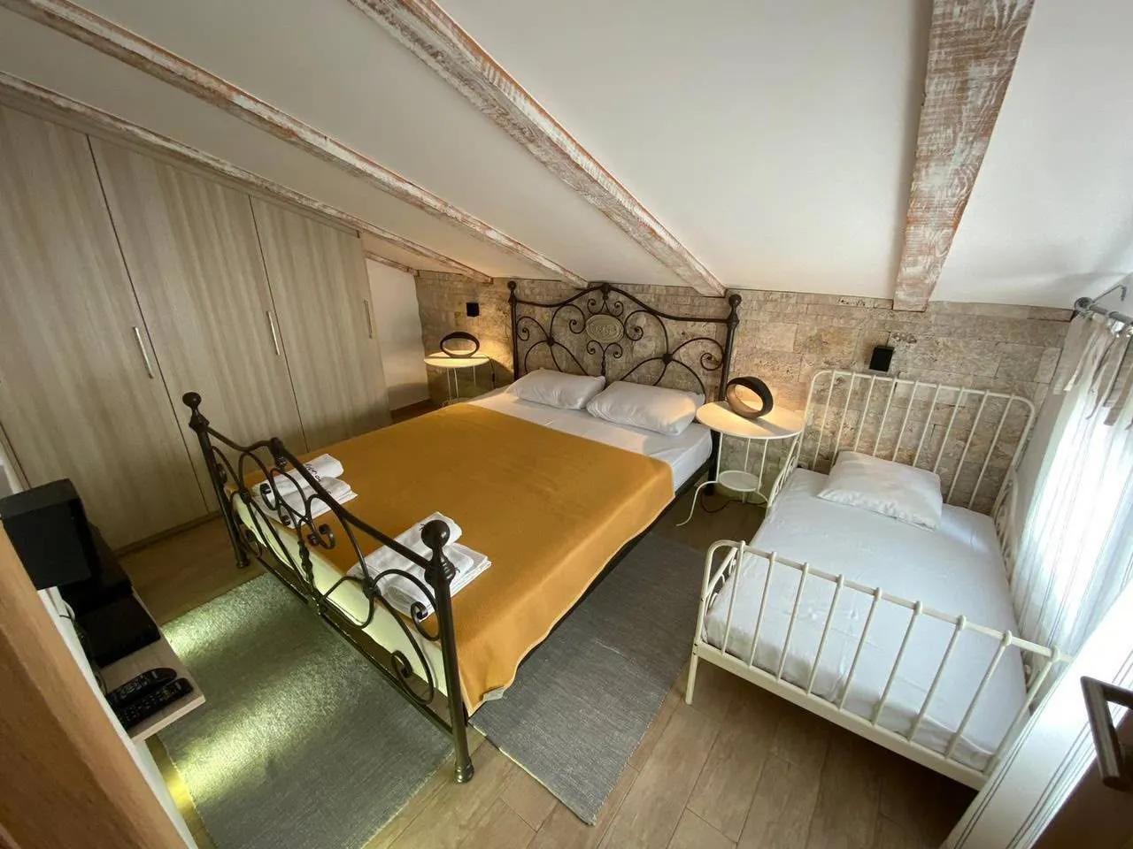 Attic bedroom with two beds and wooden beams.