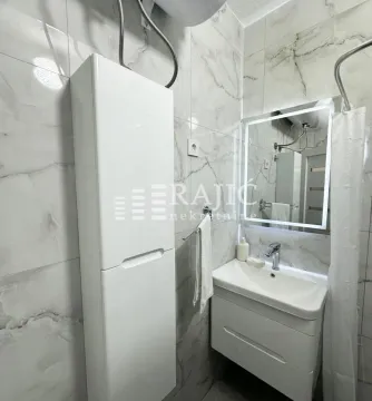 Modern bathroom with a sink, mirror, and white cabinetry. - image 9