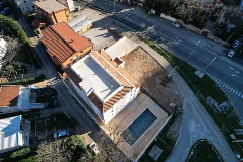Pogled iz vazduha na stambenu zgradu sa bazenom i okolnim dvorištem. - image 11