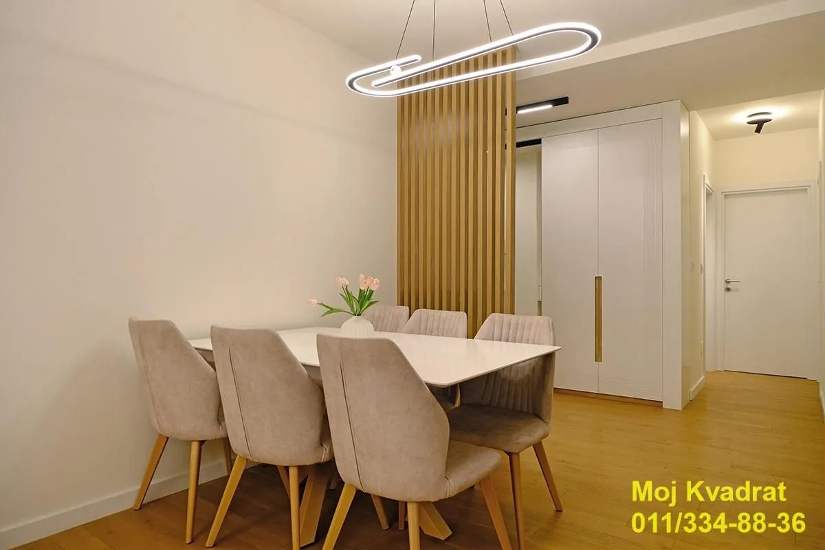 Dining area with a table, chairs, and modern lighting.