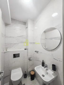 Modern bathroom with white tiles, washbasin and toilet. - image 8