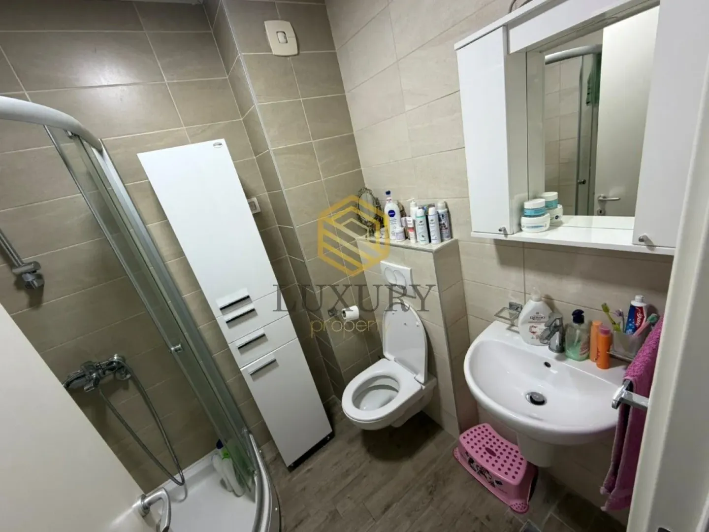 Modern equipped bathroom with a shower cabin, washbasin, and toilet.