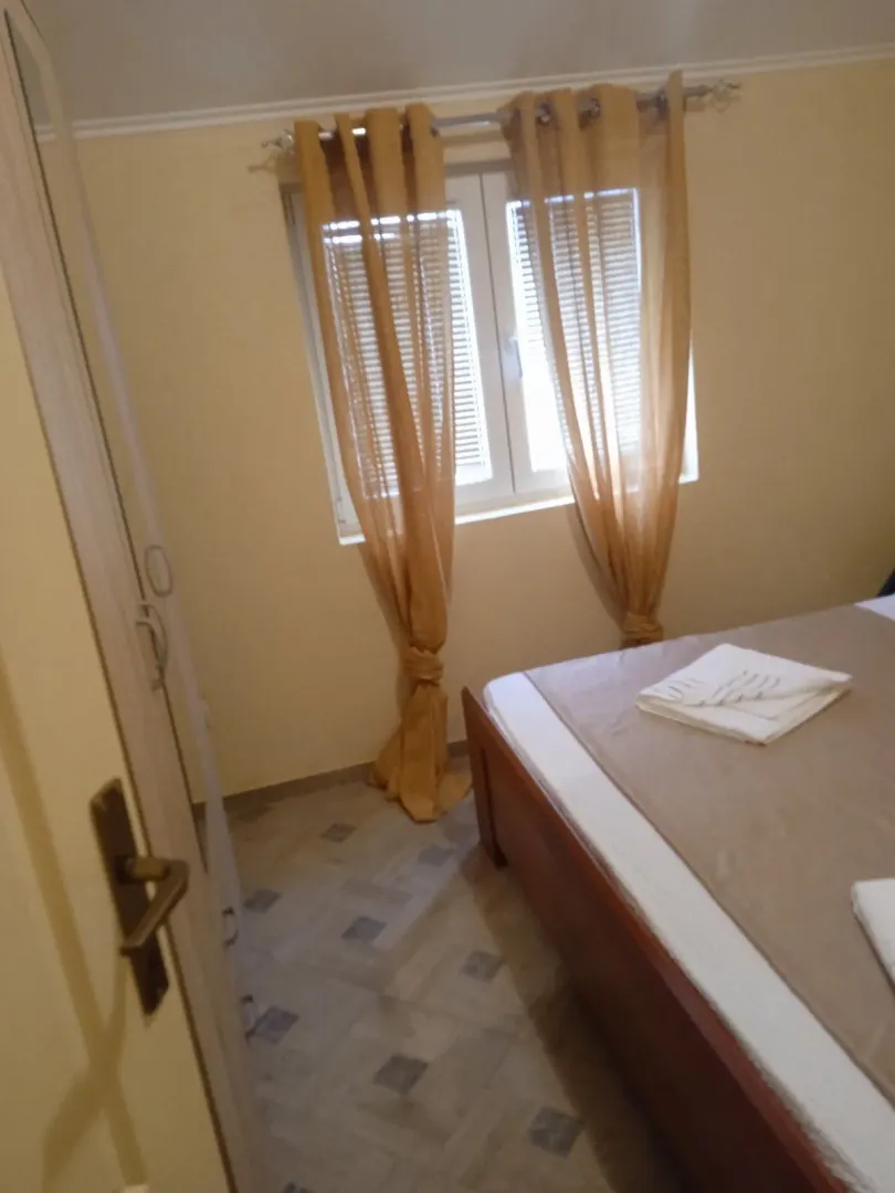 Furnished bedroom with a bed and a window.