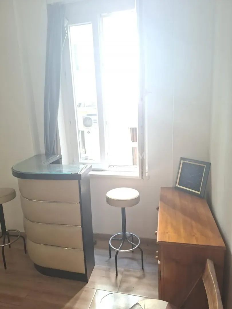 Small space with a bar counter, bar stools, and a window letting in plenty of light.
