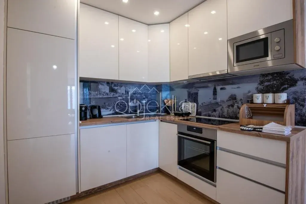 Modern kitchen with built-in appliances and white glossy fronts.
