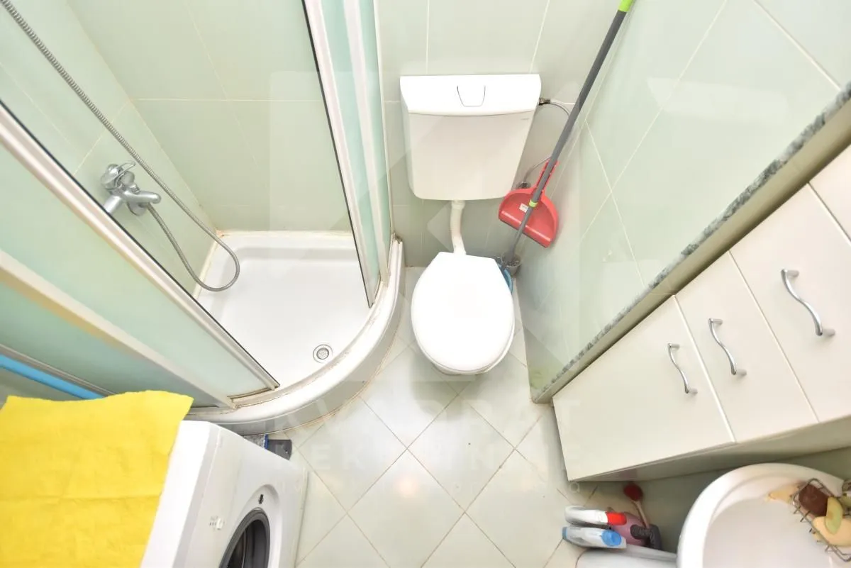 Top-down view of a bathroom with a shower cabin, toilet, and washbasin.