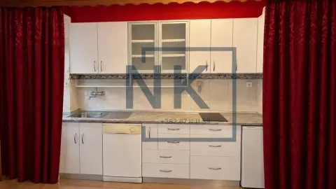 White kitchen with a sink, built-in cooktop, and cabinetry framed by red curtains. - image 6