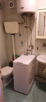 Small bathroom with sanitary fixtures, washing machine, and water heater. - image 6