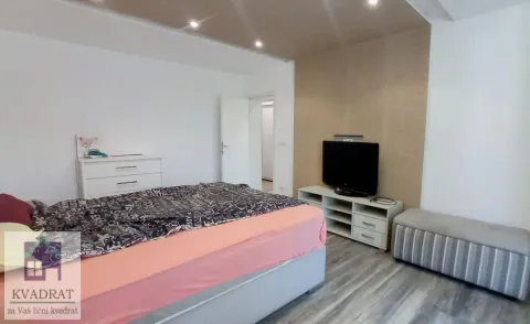 Nameštena spavaća soba sa bračnim krevetom, komodom i televizorom. - image 7