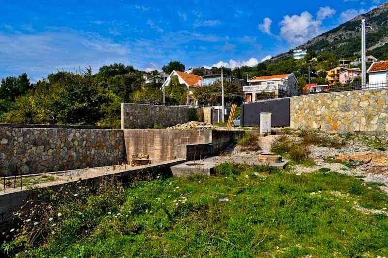 Pogled na plac sa temeljem i okolnim kućama u naselju.