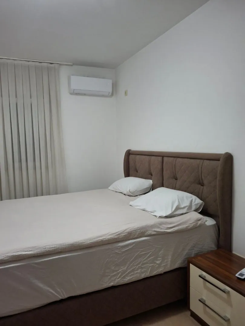 Bedroom with a double bed, nightstand, and air conditioning.