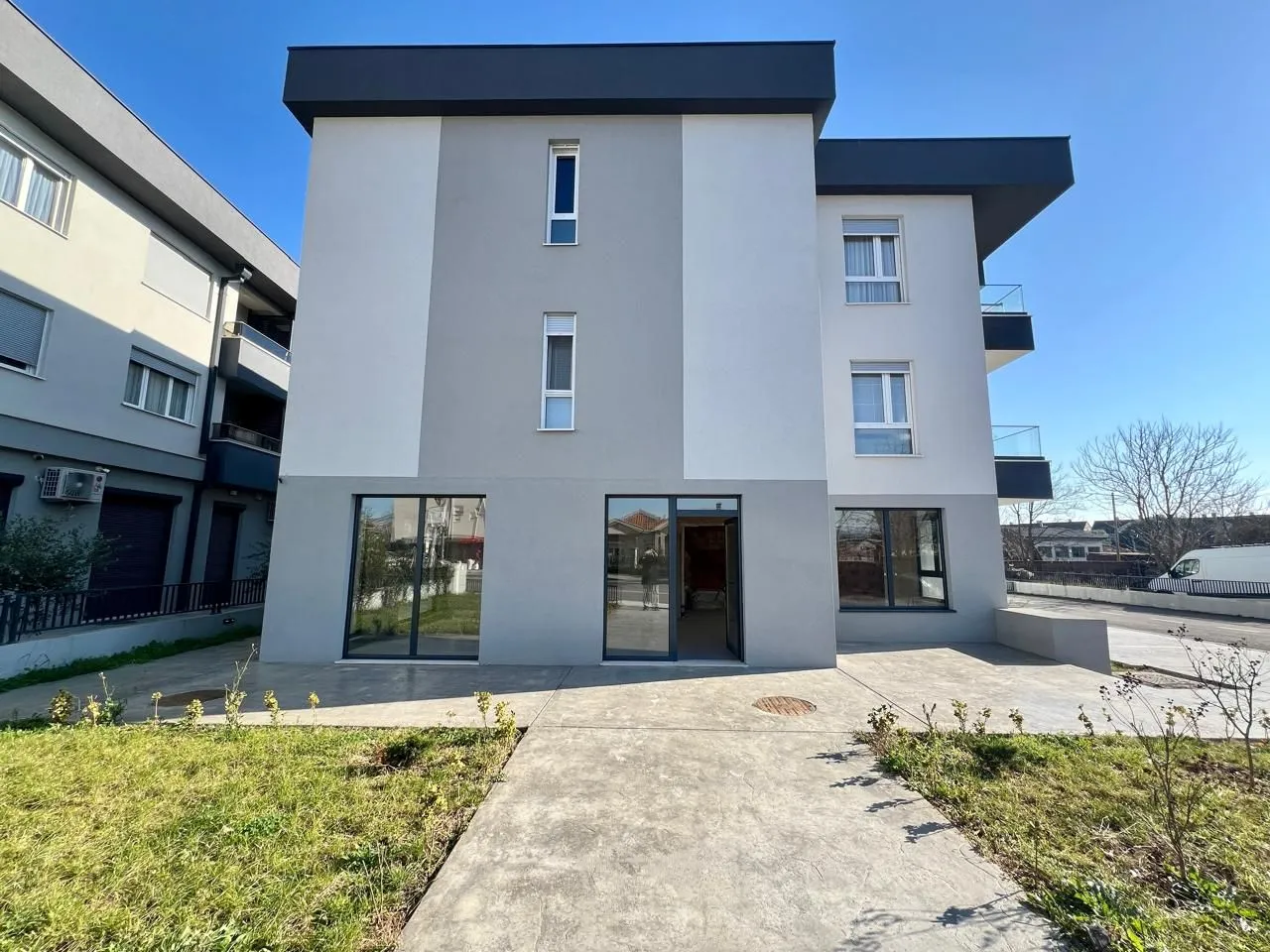 Front view of a modern residential building with a yard.