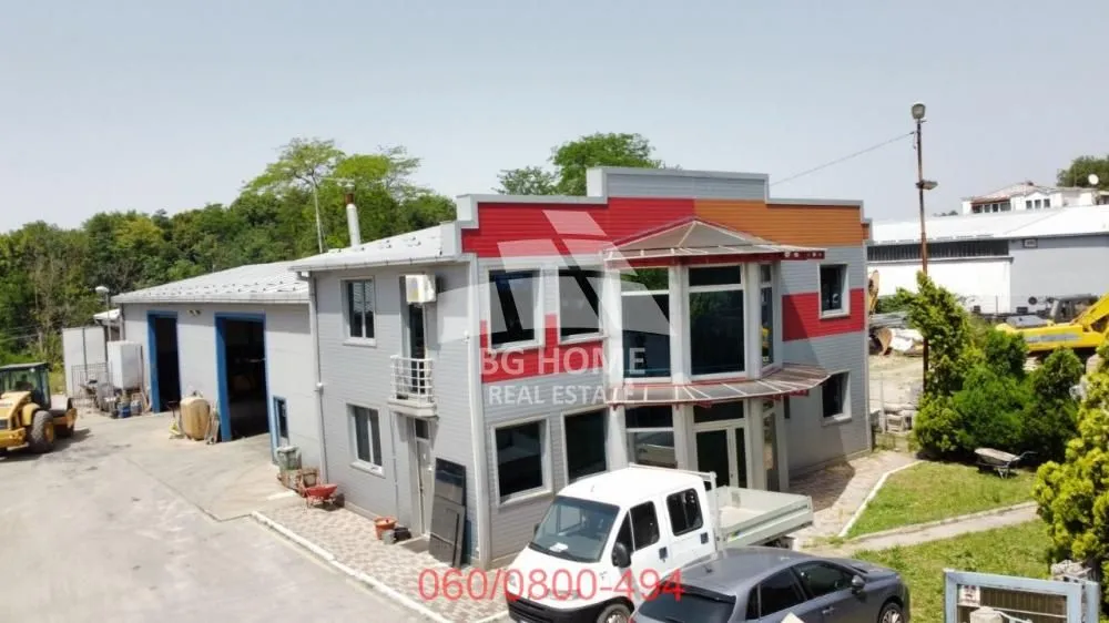 Aerial view of a commercial building with a courtyard and parked vehicles.