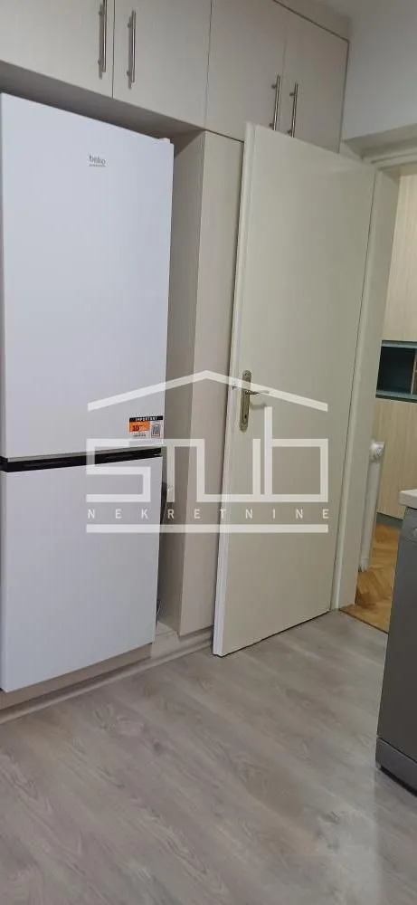View of a part of the kitchen with a refrigerator and kitchen cabinets.