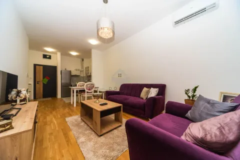 Dnevna soba sa ljubičastim garniturama, drvenim stolićem i pogledom na kuhinju. - image 11