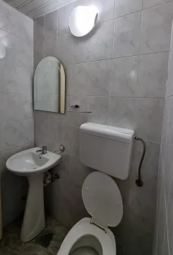 A simple bathroom with a sink, mirror, and toilet. - image 10