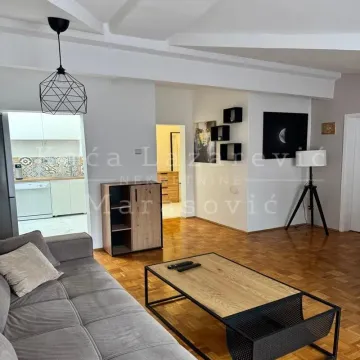 Spacious living room with a sofa and a view towards the kitchen. - image 3