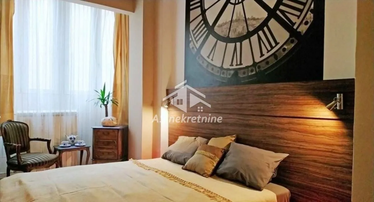 Furnished bedroom with a large double bed and a decorative wall.