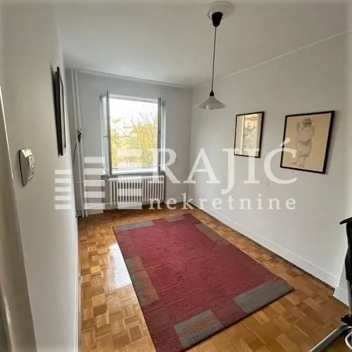 Empty room with parquet flooring and a red rug.
