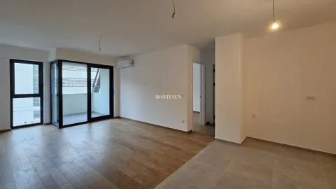 Prostrana prazna dnevna soba sa drvenim podom i izlazom na terasu. - image 5