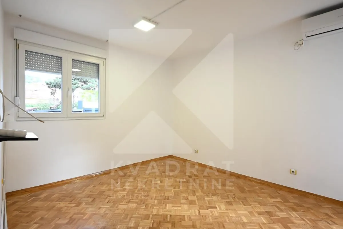 Empty room with parquet flooring and white walls.
