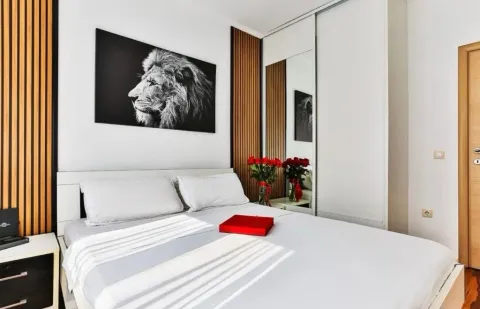 Modern bedroom with a double bed, fitted wardrobe, and decorative wall panels. - image 9