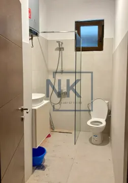 Bathroom equipped with a glass-partition shower cabin, washbasin, and toilet. - image 7