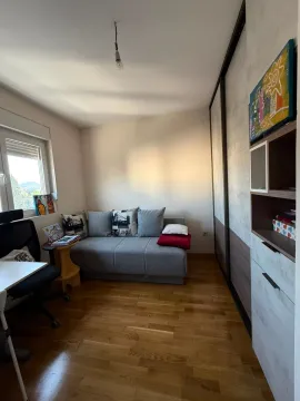 Small room with a pull-out sofa, desk, and wardrobe. - image 9