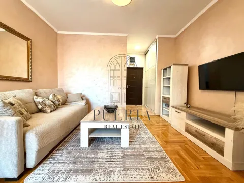 Living room with a sofa, TV, and dining area. - image 3