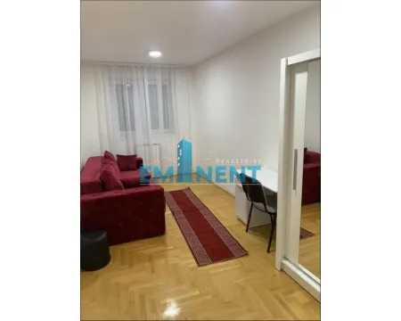 Dnevna soba sa crvenom garniturom, radnim stolom i ormarom sa ogledalom. - image 8